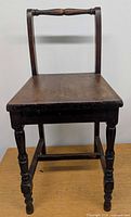 Frontal view of chair showing turned legs, seat, and back