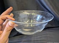 side view of clear dimpled glass bowl held by hand