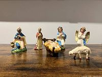 Front view of six nativity pieces on wood surface