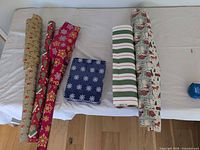 Top view showing six wrapping paper rolls and blue snowflake tin