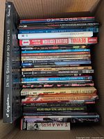 Box containing stack of graphic novels, spines visible