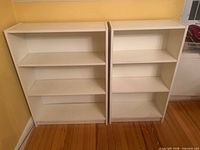 Frontal view of both white bookcases side by side