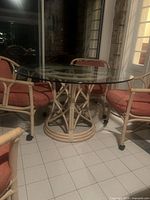 Round glass-top rattan table and two chairs in natural light beige finish