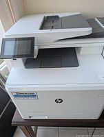 Front three-quarter view of HP MFP printer on table