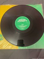 Record removed from sleeve showing green centre label and black vinyl surface