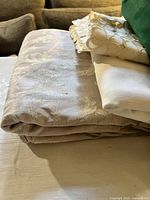 Stack showing beige damask tablecloth and two white runners