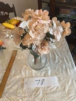 Full view of glass vase and peach silk flower bouquet with ruler for scale