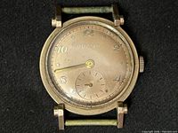 Front view of Bulova wristwatch case showing dial, hands, patina, and lugs