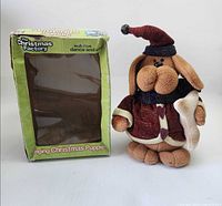 Plush dog standing beside green window box