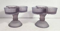 Two identical pink satin pressed glass triple votive candle holders on white background