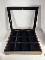 Open wooden tea box showing 12 compartments and glass lid