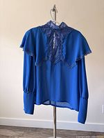 Front view of cobalt blue Marc Alan blouse on hanger