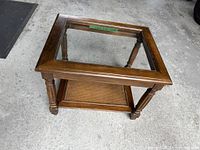 Oblique view of wood frame end table showing glass top and cane shelf