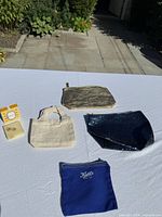 Overview of earrings, three pouches and mini tote laid out on table