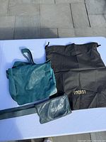 Crossbody bag, waist pack, shoulder strap and dust bag laid out