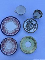Assorted saucers and two cups showing various patterns and gold gilt