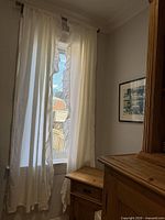 Full view of both white ruffled curtain panels hung on rod