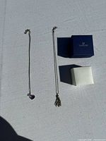Two necklaces laid out with two boxes visible