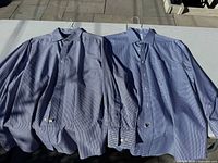 Both blue gingham dress shirts laid flat to show front and pattern