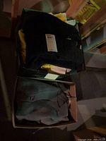 Two boxes containing folded sweaters, dark lighting