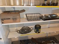 All items on shelving: oval tray, rectangular basket, scoop planter on metal tray, decorative sun tin canister
