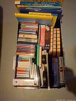 Top view of entire lot showing CDs, books and board game boxes within storage box