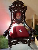 Front view of ornate carved wood armchair