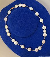 Necklace laid circular on blue surface showing full strand