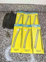 Overview of six packaged curved track packs, loose curved track sections, and rail joiners
