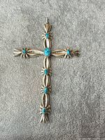 Full view of large sterling silver cross pendant with turquoise cabochons