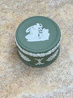 Top view showing white neoclassical relief on green lid