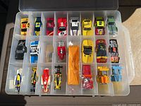 Top view of storage case open showing 24 of the slot car bodies positioned in individual compartments