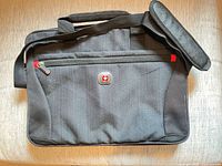 Front view of Swissgear laptop bag showing logo, front zip pocket, shoulder strap