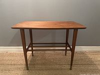 Front angled view of walnut side table showing top, legs, and lower slatted shelf
