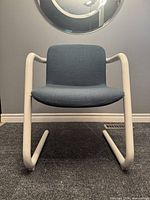 Front view of blue upholstered cantilever chair with white tubular frame