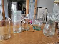 Front view of five glass vases showing shapes and green tint