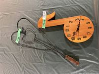 Wood musical note clock and black metal heart stake on table