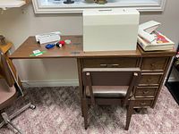 Sewing table extended with machine case, chair, accessories visible