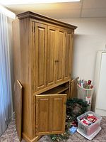 Full view of oak corner entertainment cabinet with doors