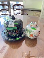 Cheese dome and ginger jar side by side on table