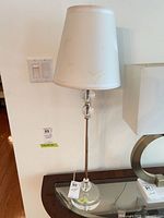 Full view of one lamp on table showing height, shape, base, shade condition