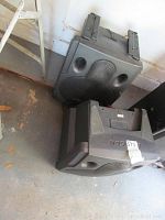 Two Samson Expedition XPRS speakers placed on the floor showing front and back sides, revealing the molded plastic housing and mounting brackets on the top.