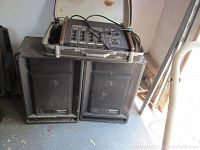 Photo showing the mixer amplifier placed on top of two black Kustom 1201P speaker cabinets with some dust and wear visible.