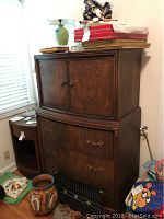Wooden wardrobe with upper cabinet closed showing design and handles.