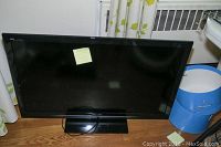 Front view of Panasonic Viera TV showing black bezel and screen, resting on wood floor.