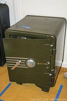 Side view of heavy Sentry Safe on wheels in olive green with door slightly open.