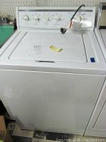 Front view of the white KitchenAid Superba top-loading washing machine showing the general condition and lid area.