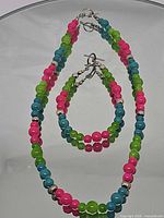 Necklace and bracelet laid flat showing bead colours and clasps