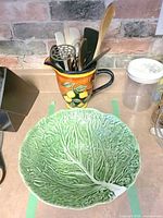 Cabbage bowl front with pitcher holding utensils