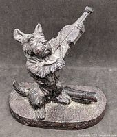 Front view of cast iron Scottie dog violin doorstop on base